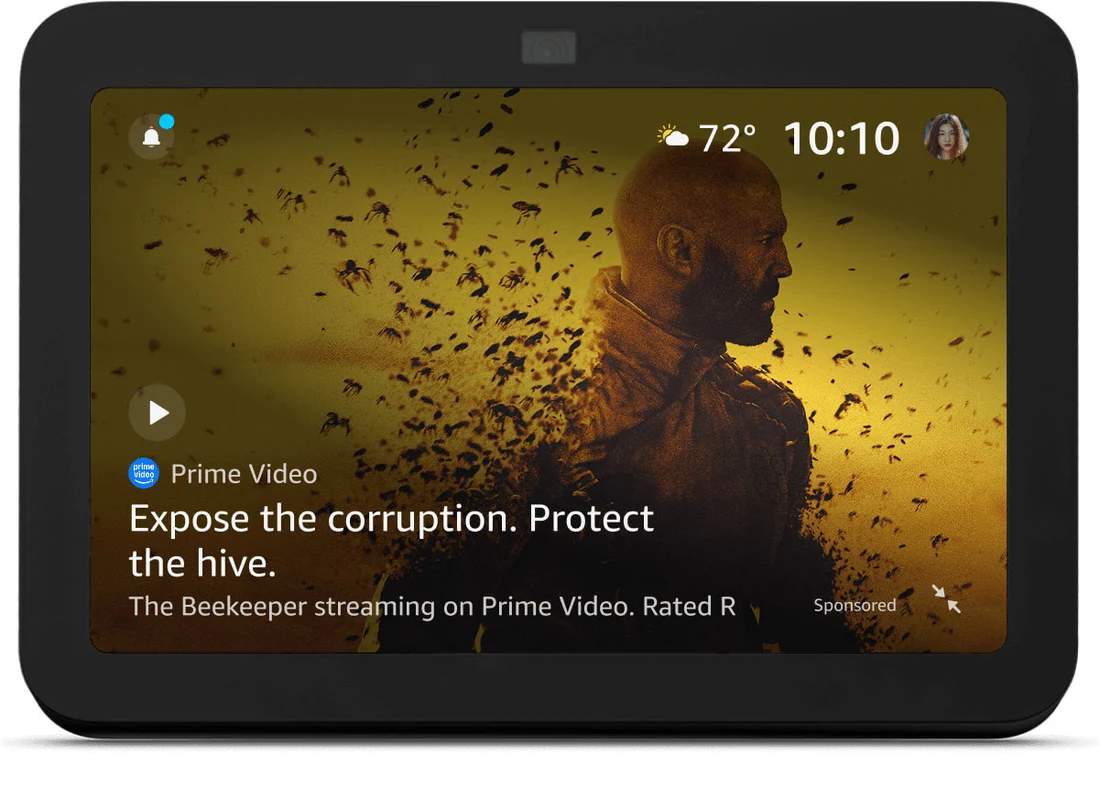 An Echo Show across the room showing a full-screen sponsored Prime Video ad for The Beekeeper, with the Prime Video logo, a headline, an image, and a Sponsored label